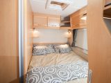 The rear fixed bed has a padded headboard, comfy mattress and reading lights