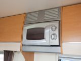 Kitchen cabinetwork houses integral microwave oven
