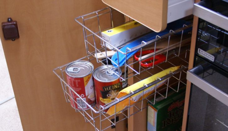 Kitchen cupboard has practical wire racks with room below for tall boxes
