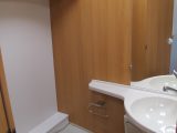 The washbasin has ample surface for toiletries and a cupboard below