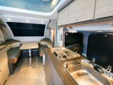 With the roof popped up on site, headroom grows to a roomy 2.17m. The kitchen is compact and short on kit often found in UK-made tourers, such as an oven. The table accommodates two diners and is part of the front bed assembly
