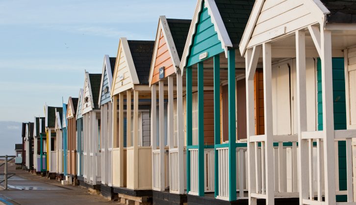 Colourful beach huts line the long sandy beach at Southwold on the Suffolk coast