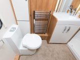 The Swift Elegance 570's washroom is fitted with an electric flush toilet, radiator-towel rail, basin and vanity unit, and a fully lined shower