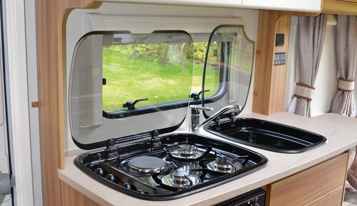 The kitchen in the Elddis Sanremo 304 offers a hob with three gas burners and an electric hotplate, plus  a combined oven and grill and a separate microwave oven