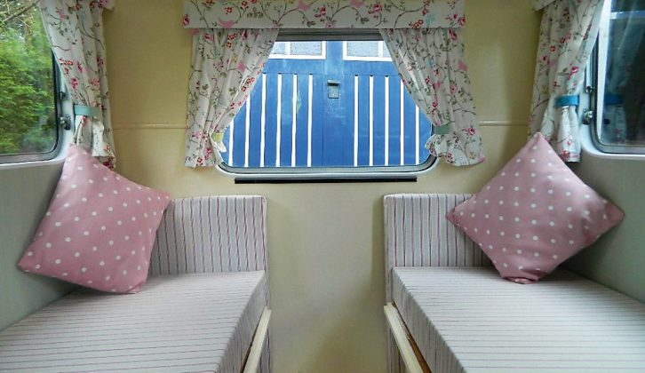 The finished, wallpapered interior of this vintage caravan is warm and welcoming