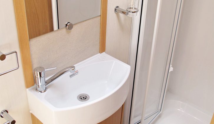 The washroom features a large basin, a chrome-effect tap and a lined shower cubicle