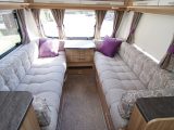The traditional caravan lounge with its neutral upholstery is brightened up with purple scatter cushions in the 2015 Quasar 646