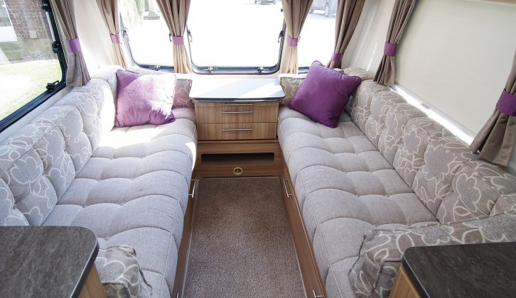 The traditional caravan lounge with its neutral upholstery is brightened up with purple scatter cushions in the 2015 Quasar 646