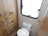 A heated towel rail helps to warm the toilet and wardrobe area within the full-width rear washroom in the luxurious Lunar Delta TS caravan