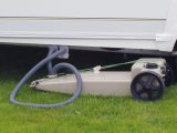 This type of waste container can usually be easily placed under a caravan, but why has this caravanner used one hose that’s too long?