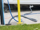 Some campsites have full-service pitches – here, waste water is carried from the caravan using a long hose