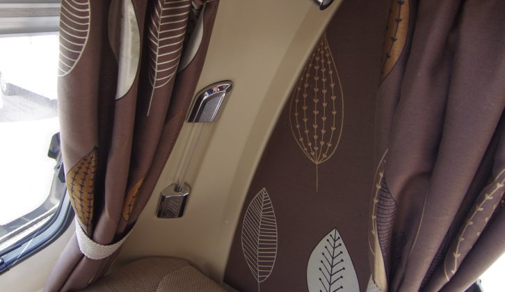 Stylish chrome fittings and chocolate brown curtains and cushions jazz up the sensibly neutral soft furnishings