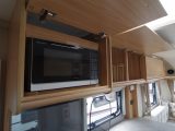 The microwave is hidden away inside one of the overhead lockers in the Vision 520/4 caravan kitchen