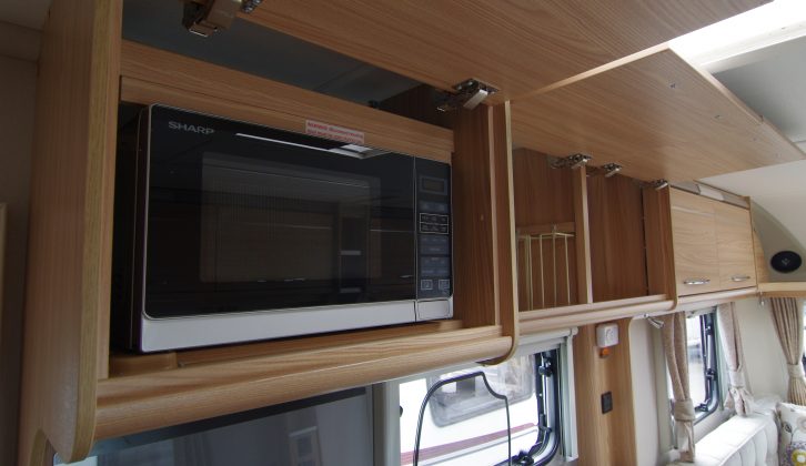 The microwave is hidden away inside one of the overhead lockers in the Vision 520/4 caravan kitchen