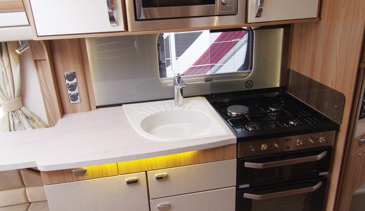 The well-equipped kitchen has a microwave oven and a Thetford Aspire 2 cooker with a dual-fuel hob and separate oven and grill, plus a worktop extension