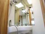 Mirrors help the washroom seem larger. A separate showerhead on a riser is provided but the walls are not lined