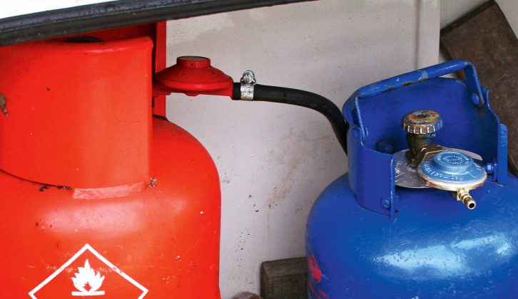A cylinder-mounted butane regulator is blue, propane is red