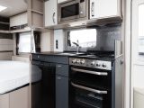 Contrasting upper and lower kitchen units feature in the Sterling Elite 630, which also has a fixed French bed and bunks