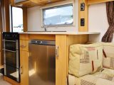 The nearside galley kitchen is well-equipped, with ample worktop and storage, and essential appliances
