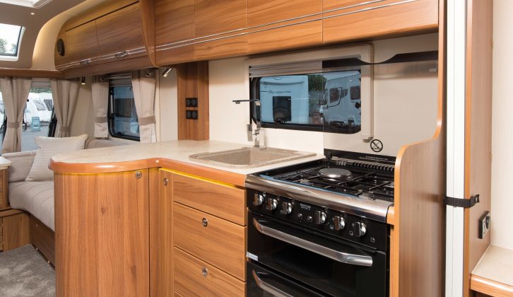 The kitchen has a circular cupboard, an oven and grill, and a dual-fuel hob