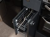 The kitchen has practical pull-out wire baskets and a large cutlery drawer