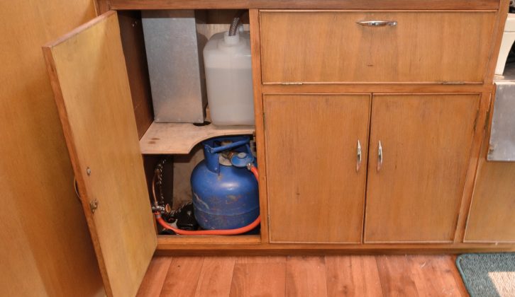 Gas and water are kept in the end kitchen's lower cupboard in the old Stirling caravan