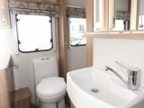 The washroom has a Thetford electric flush loo, while a backlit mirror sits above the sink