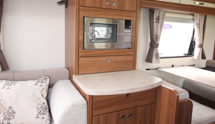 A microwave above a handy shelf sits opposite the main kitchen area in the Elddis Affinity 530