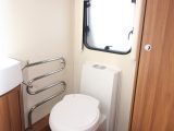 There's a Thetford electric flush toilet with yet more storage above in the 530's end washroom