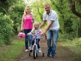 Stacie and Brian teach their daughter Isabelle how to ride a bike in the Cotswolds