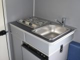 The simple kitchen features a sink/hob unit that can be moved outside