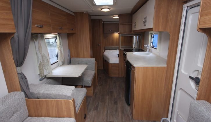 Beyond the lounge, the side dinette sits opposite the kitchen and you can see the fixed double bed further back