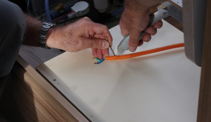 Disconnect wires, pass the orange cable back into the van and carefully cut back the sheath