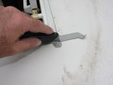 Trim the excess mastic sealing strip, taking care not to damage the roof’s surface