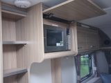 The microwave is located on the nearside wall in its own cupboard, but might be set too high for some caravanners