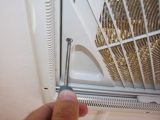 2 Remove the four crosshead screws that hold the lower slatted grille in place