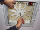 Hold one of the blades to keep the fan still as you undo the securing nut with a spanner