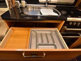 This handy cutlery drawer, a cupboard beneath, plus overhead lockers, give ample storage space in the kitchen
