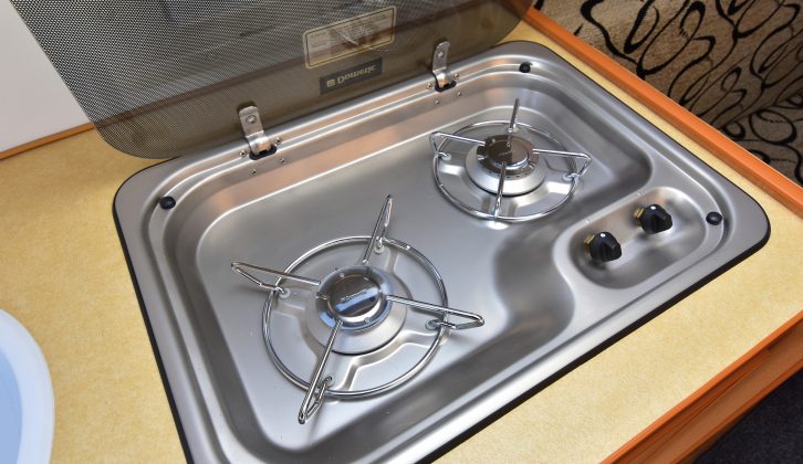 The two-burner hob has a glass lid to help increase food prep space