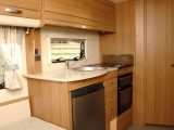 The practical kitchen has a large stainless-steel sink and enough worktop space