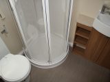 The separate shower cubicle in the end washroom has moulded shelves for toiletries