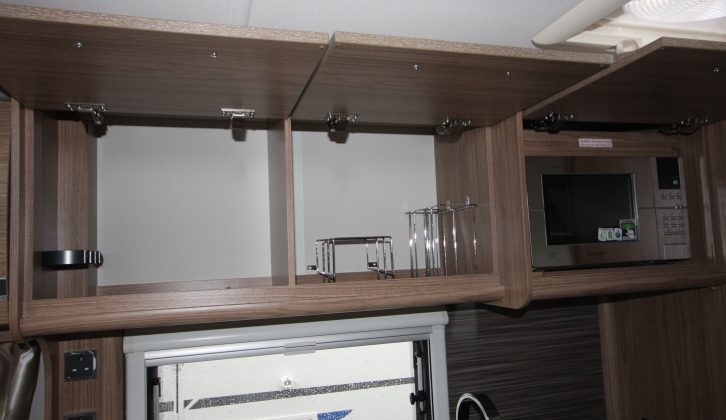 There are three overhead lockers in the kitchen, one of which houses the microwave, plus there are two 230V sockets
