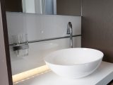 Using the same system as in the kitchen, you can slot a toothbrush holder into the groove behind the sink