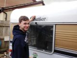 Maintaining the old caravan is a generation thing: here's Nigel's son Phil rubbing down the lettering