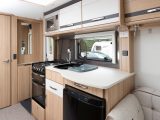 The Coachman Pastiche 520's kitchen has a fridge, a microwave, a dual-fuel hob, and a separate oven and grill