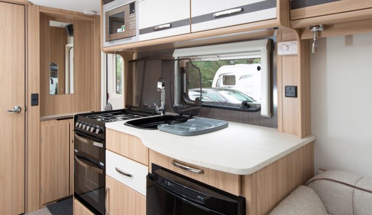 The Coachman Pastiche 520's kitchen has a fridge, a microwave, a dual-fuel hob, and a separate oven and grill