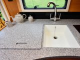 The Corian/Tristone worktops look good and are practical, while the large kitchen sink has a matching lid to create even more workspace