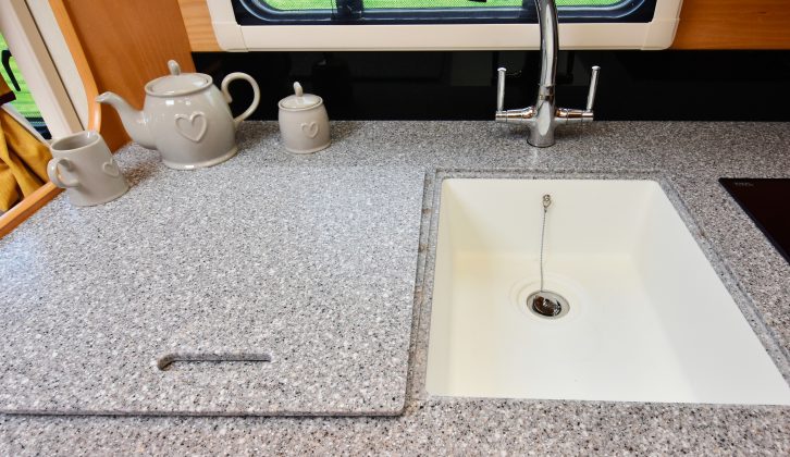 The Corian/Tristone worktops look good and are practical, while the large kitchen sink has a matching lid to create even more workspace