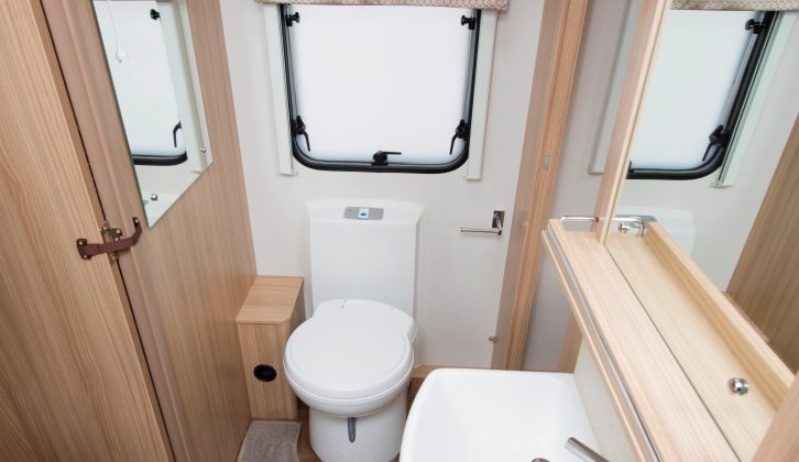 The frosted window allows plenty of light into the Coachman Vision 545's central washroom