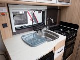 The cream worktop in the kitchen will easily suffice for a couple, while a glass panel protector for the washroom bulkhead is a welcome detail